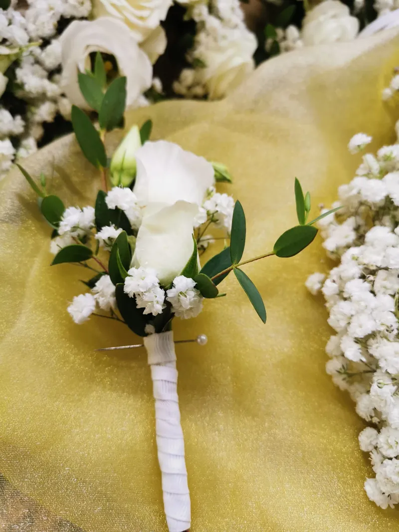 Alfinete de lapela com rosa branca, lisianthus e folha de eucalipto