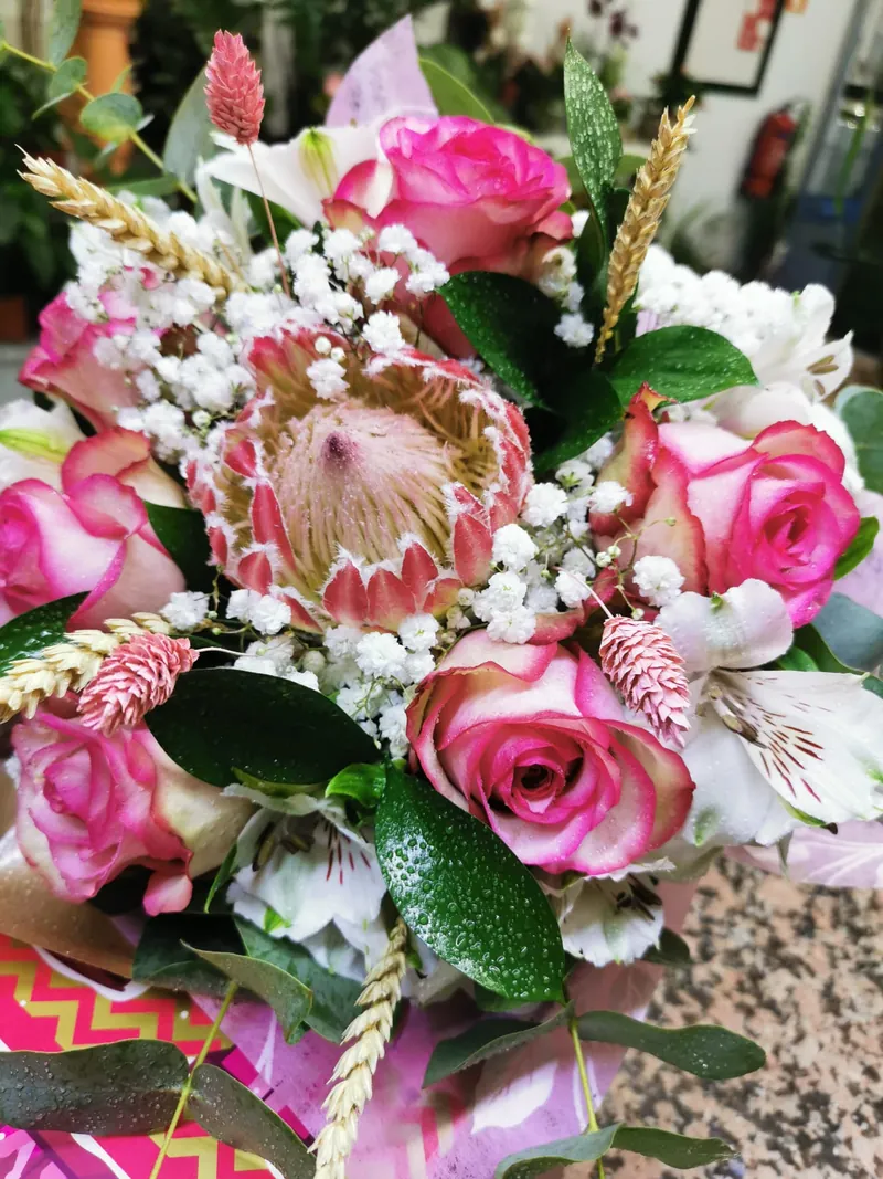 Ramo em tons de rosa com protea, rosas cor-de-rosa e alstroeméria